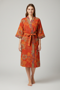 Femme en robe de chambre kimono japonais orange à motifs floraux rouille et violet